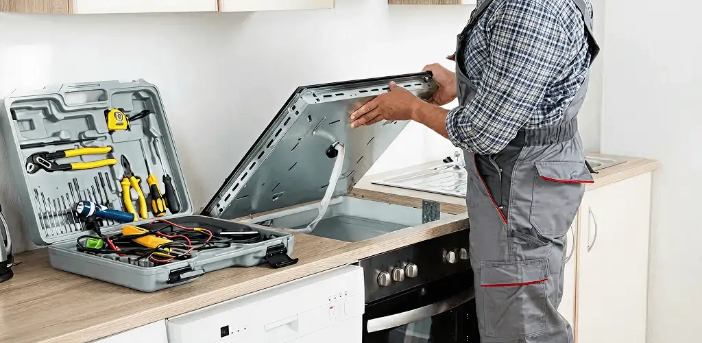 Handyman repairing a cooktop and checking wiring connections in Naperville, IL