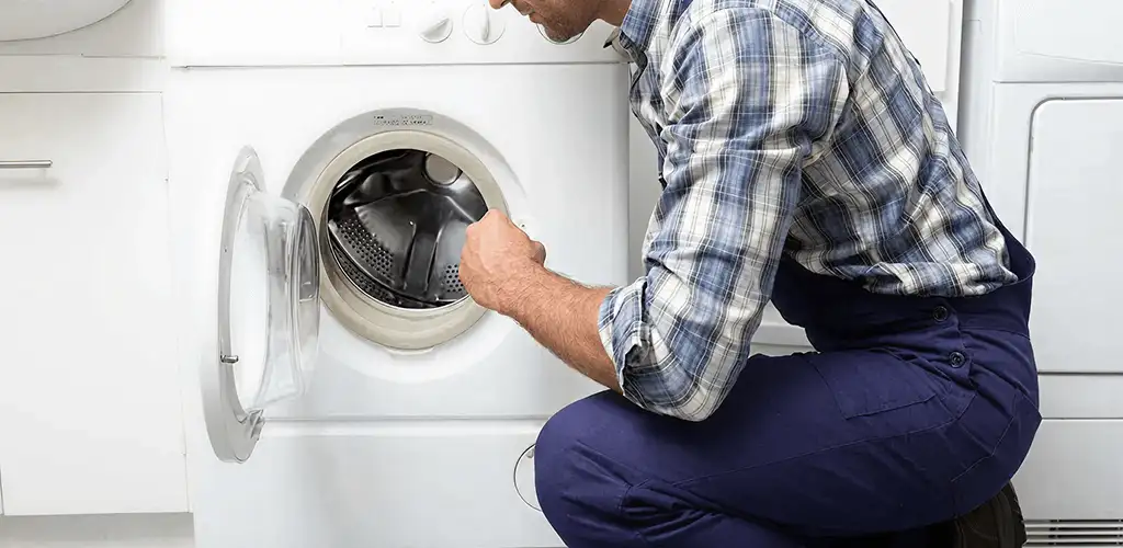 Handyman inspecting a dryer drum and internal parts for repair in Naperville, IL
