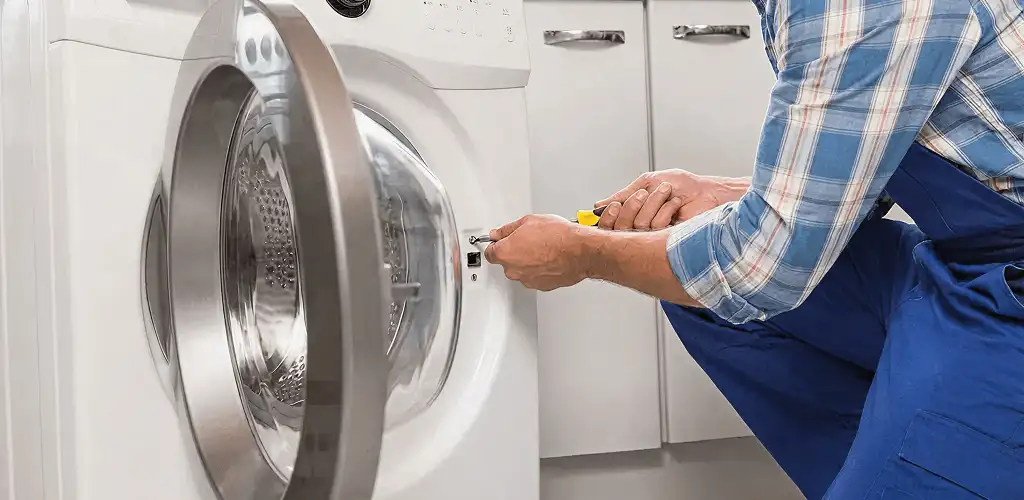 Handyman repairing a clothes dryer and checking electrical connections in Naperville, IL
