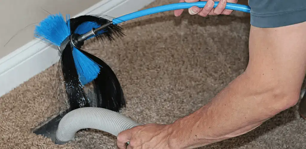 Dryer vent cleaning technician brushing lint from a vent line in Naperville, IL