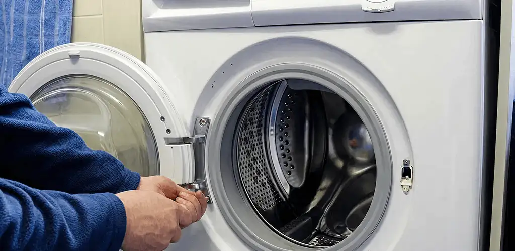 Washing machine repair handyman checking a front-load washer door and latch in Naperville, IL