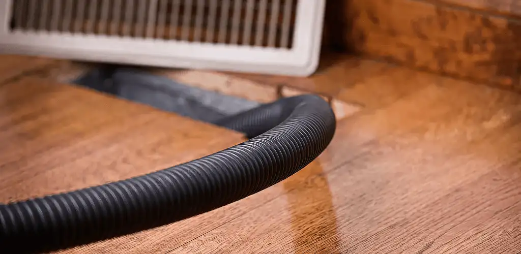 Air duct cleaning hose inserted into a floor vent for ductwork cleaning in Naperville, IL