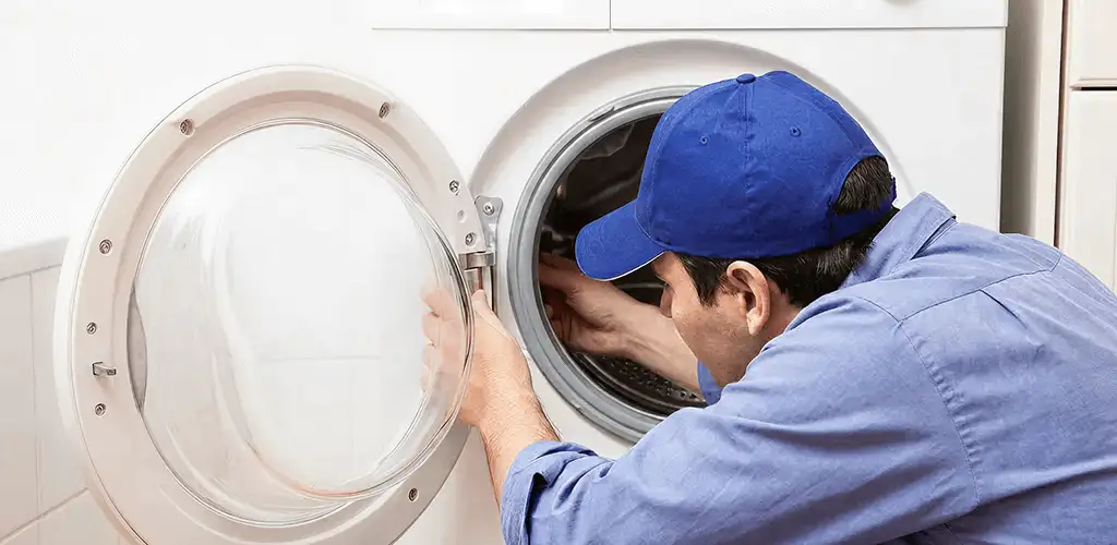 Washing machine repair handyman inspecting a front-load washer drum in Naperville, IL